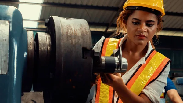 Skillful factory woman worker do machine job in manufacturing workshop