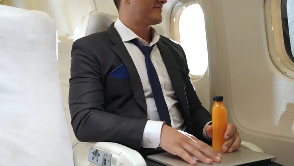 Businessman have orange juice served by an air hostess in airplane — Stock Photo, Image
