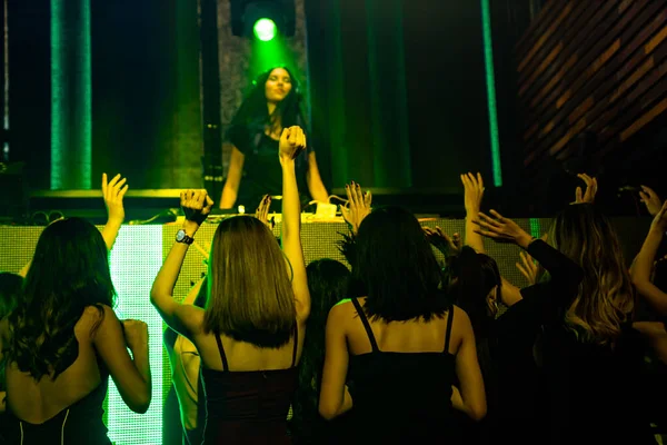 Ομάδα ανθρώπων χορεύουν στο νυχτερινό κλαμπ ντίσκο στο ρυθμό της μουσικής από DJ στη σκηνή — Φωτογραφία Αρχείου