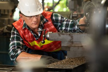 Akıllı fabrika işçisi veya mühendisi bir imalat atölyesinde makine işi yapıyor.