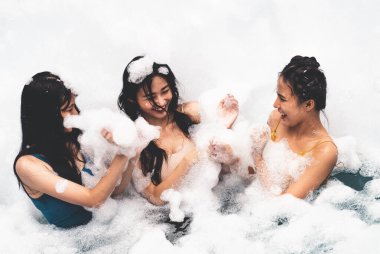 Eğlence ve neşeyle kabarcık havuzunda oynayan kız