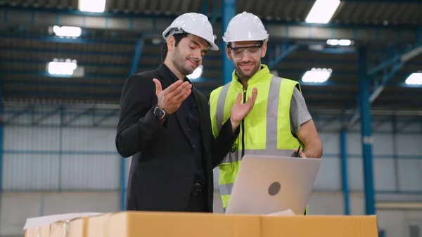Två fabriksarbetare arbetar och diskuterar tillverkningsplan i fabriken . — Stockfoto