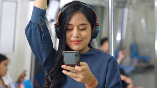 Jeune femme utilisant un téléphone portable dans le train public — Photo