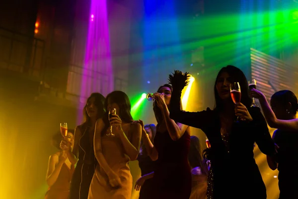 Silhuett bild av människor dansa i disco nattklubb till musik från DJ på scenen — Stockfoto