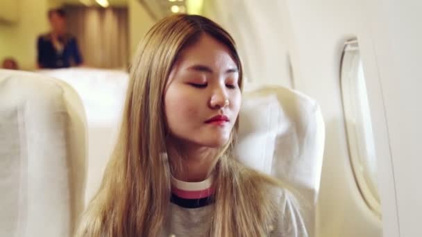 Glad asiatisk kvinna reser i flygplan — Stockvideo
