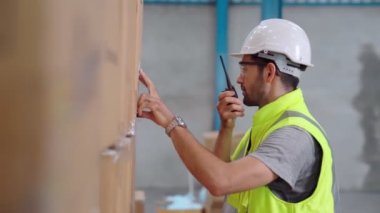 Profesyonel kargo işçisi başka bir işçiyle bağlantı kurmak için telsizle konuşuyor.