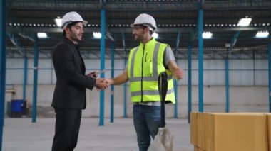 Fabrika işçileri depodaki bir yük arabasında kutu teslimatı yapıyor. .