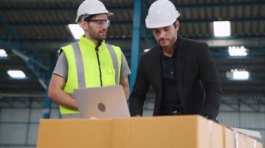 Fabrikada çalışan ve üretim planını tartışan iki fabrika işçisi. .