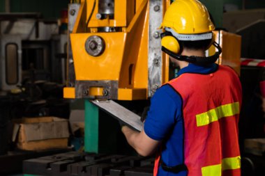 Fabrika işçisi veya mühendisi imalat atölyesinde makine işi yapıyor.