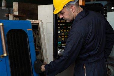 Fabrika mühendisi veya işçisi üretim atölyesinde makine işi yapıyor.