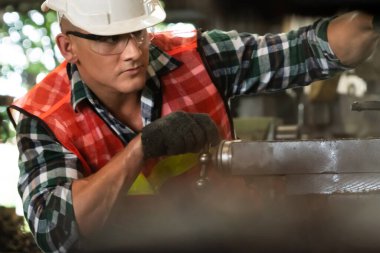 Akıllı fabrika işçisi veya mühendisi bir imalat atölyesinde makine işi yapıyor.