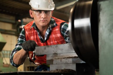 Akıllı fabrika işçisi veya mühendisi bir imalat atölyesinde makine işi yapıyor.