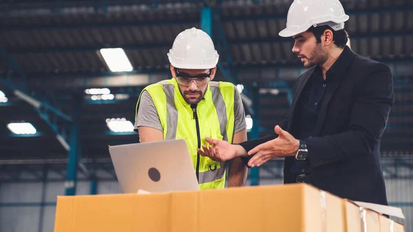 Två fabriksarbetare arbetar och diskuterar tillverkningsplan i fabriken . — Stockfoto