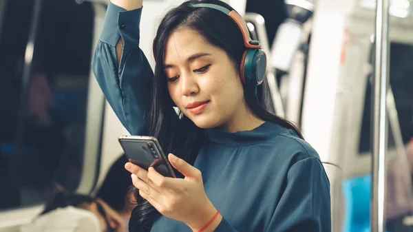 Ung kvinna som använder mobiltelefon på offentligt tåg — Stockfoto