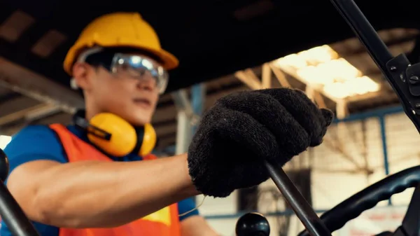 Un travailleur habile conduit un chariot élévateur à fourche dans l'usine . — Photo