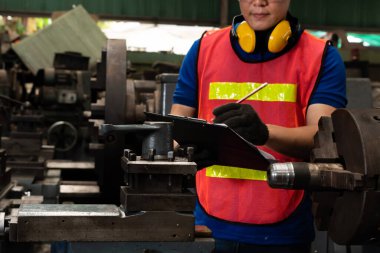 İşlemleri kontrol etmek için pano ile çalışan yetenekli bir fabrika işçisi. .