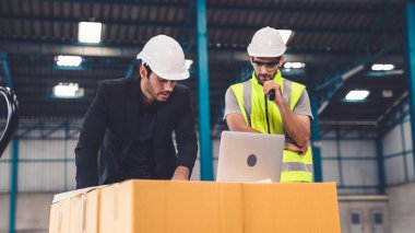 Fabrikada çalışan ve üretim planını tartışan iki fabrika işçisi. .