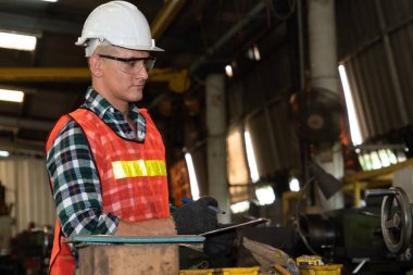 Akıllı fabrika işçisi veya mühendisi bir imalat atölyesinde makine işi yapıyor.