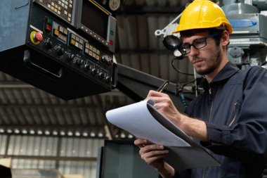 İşlemleri kontrol etmek için pano ile çalışan yetenekli bir fabrika işçisi. .