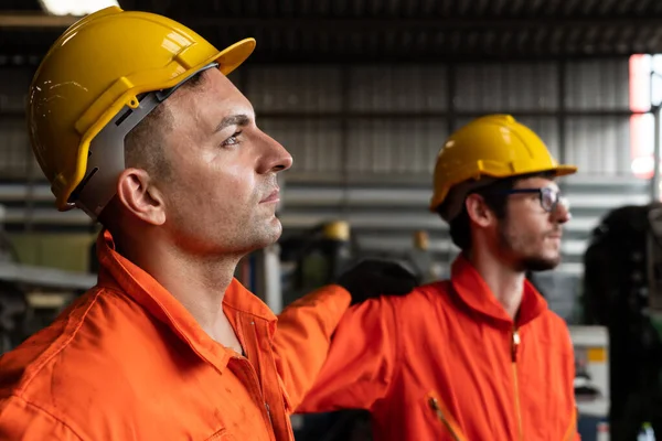 Dos hábiles ingenieros de fábrica o trabajadores que muestran trabajo en equipo y asociación . — Foto de Stock