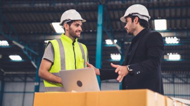 Fabrikada çalışan ve üretim planını tartışan iki fabrika işçisi. .