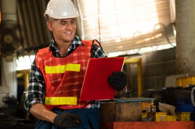 İş prosedürü kontrol listesi için pano ile çalışan imalat işçisi .