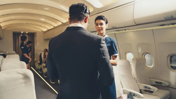 Kabinenpersonal begrüßt Passagier im Flugzeug — Stockfoto