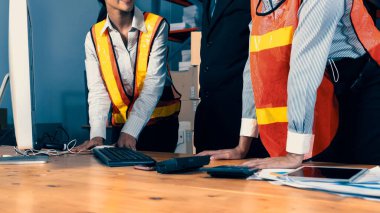 Depo müdürü ve işçisi depoda çalışıyor.