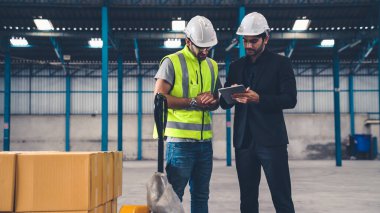 Fabrikada çalışan ve üretim planını tartışan iki fabrika işçisi. .