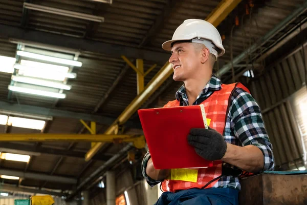 Trabajador de fabricación que trabaja con portapapeles para hacer la lista de verificación del procedimiento de trabajo . — Foto de Stock