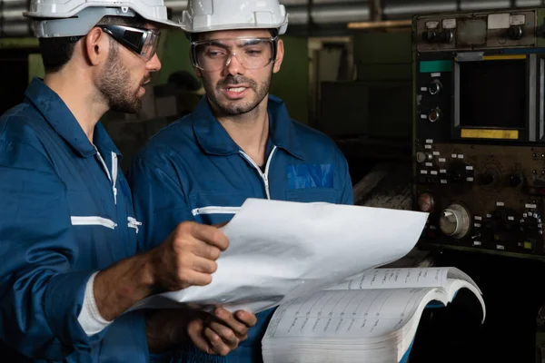 Gruppo di operai qualificati che utilizzano attrezzature per macchine in officina — Foto Stock