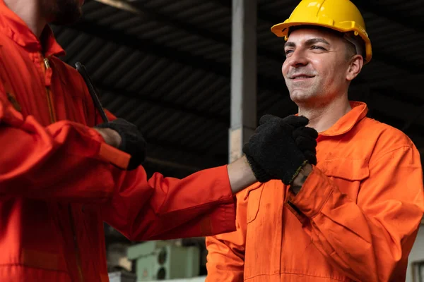 Dos hábiles ingenieros de fábrica o trabajadores que muestran trabajo en equipo y asociación . — Foto de Stock