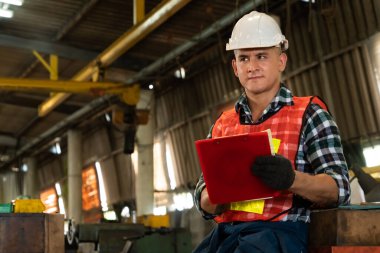 İş prosedürü kontrol listesi için pano ile çalışan imalat işçisi .