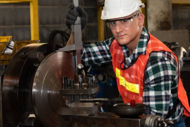 Akıllı fabrika işçisi veya mühendisi bir imalat atölyesinde makine işi yapıyor.