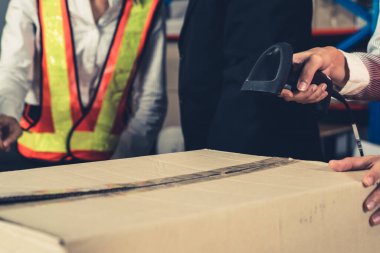 Depo çalışanı depoda barkod tarayıcısı kullanıyor.