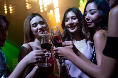 Gençler parti veriyor, içiyor ve dans ediyor.