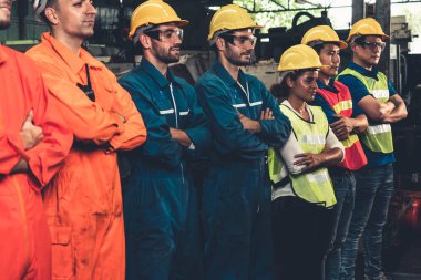 Fabrikadaki takım çalışmasını gösteren becerikli bir işçi bir arada duruyor. .