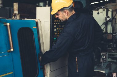 Fabrika mühendisi veya işçisi üretim atölyesinde makine işi yapıyor.