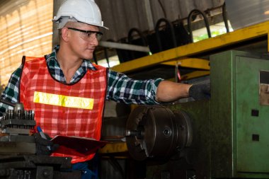 Akıllı fabrika işçisi veya mühendisi bir imalat atölyesinde makine işi yapıyor.