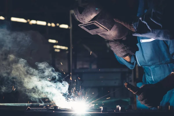 Trabalhador de metal hábil trabalhando com máquina de solda a arco na fábrica — Fotografia de Stock