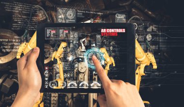 Mühendis, artırılmış gerçeklik endüstrisi teknolojisiyle robotik kolları kontrol ediyor.