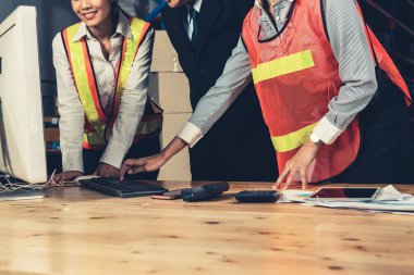 Depo müdürü ve işçisi depoda çalışıyor.