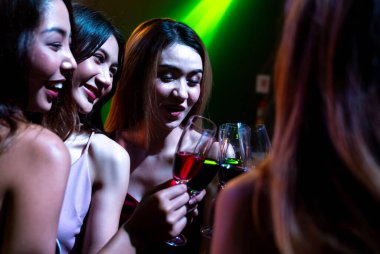 Gençler parti veriyor, içiyor ve dans ediyor.