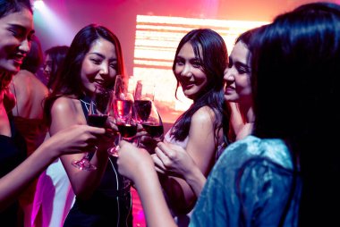 Gençler parti veriyor, içiyor ve dans ediyor.