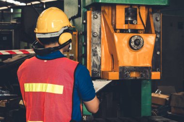 Fabrika işçisi veya mühendisi imalat atölyesinde makine işi yapıyor.