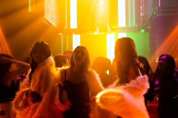 Silhouet beeld van mensen dansen in disco nachtclub op muziek van DJ op het podium — Stockfoto