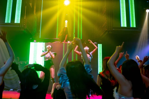 Група людей танцює в нічному клубі диско до біту музики від DJ на сцені — стокове фото