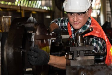Akıllı fabrika işçisi veya mühendisi bir imalat atölyesinde makine işi yapıyor.
