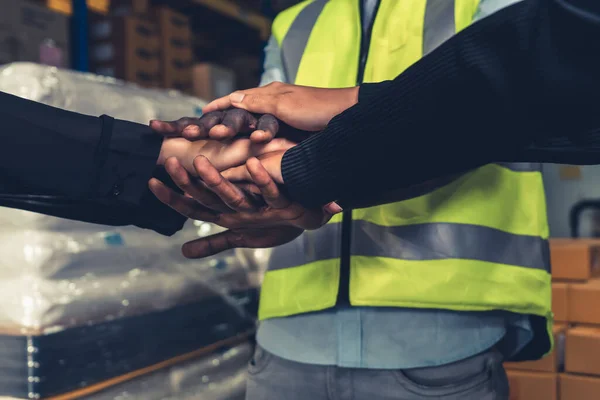 Trabalhadores da fábrica empilhando as mãos juntas em armazém ou armazém — Fotografia de Stock