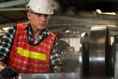 Akıllı fabrika işçisi veya mühendisi bir imalat atölyesinde makine işi yapıyor.